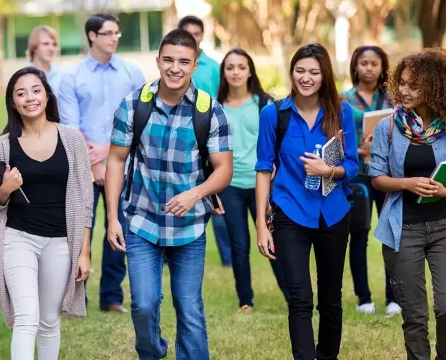 Diverse group of college students walking on beautiful campus